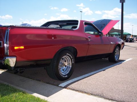 1972 Ford Ranchero - A red 1972 Ford Ranchero is parked with its hood open, showing a two-tone engine bay.
