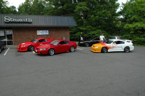 2000 Ford Mustang - Several Ford Mustangs are gathered in a parking lot in front of a Stewart's store.