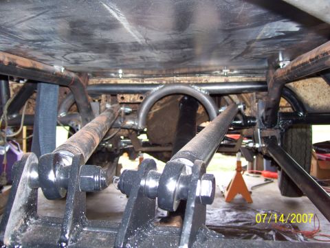 1978 Ford Bronco - The underside of a vehicle shows extensive modifications to its suspension and frame.
