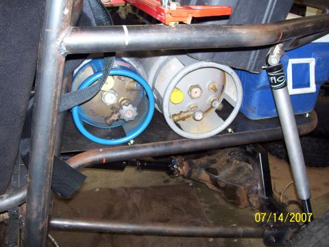 1978 Ford Bronco - Propane tanks and shock absorber mounted within a vehicle's roll cage structure.