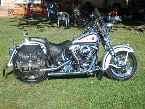 1999 Harley-Davidson Softail - A silver 1999 Harley-Davidson Softail motorcycle with fringed saddlebags is parked on a grassy lawn.