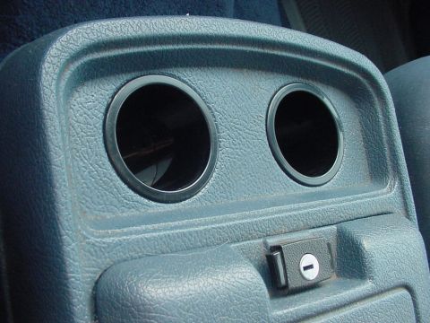 1988 Ford Bronco interior center console with two cup holders and a small lockable compartment