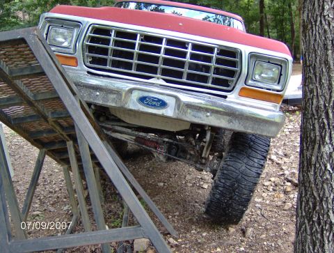 1978 Ford Bronco - A red 1979 Ford F-Series truck is positioned on a metal ramp, showing its front grille and headlights.