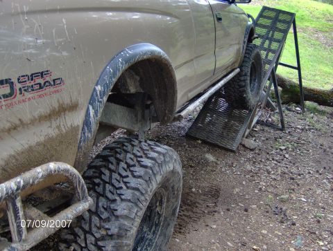1978 Ford Bronco - A Toyota truck with 'Off Road' graphics is shown using a ramp to ascend an incline.