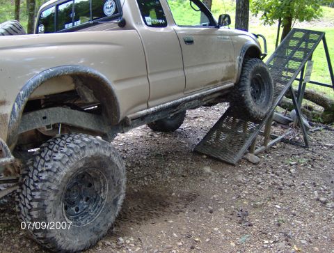 1978 Ford Bronco - Pickup truck positioned on a metal ramp in an outdoor setting.