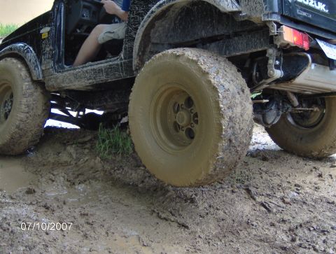 1978 Ford Bronco - This off-road vehicle navigates a muddy terrain, with its tires caked in mud.