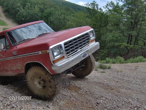 1978 Ford Bronco - 1978 Ford Bronco navigating a rocky, off-road trail on a cloudy day.