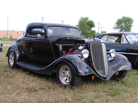 1989 Ford Mustang - A classic hot rod coupe is displayed outdoors, with its engine partially visible under the hood.