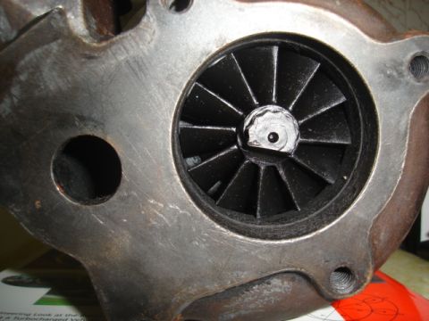 1995 Mazda MX-6 - Close-up of a turbocharger's turbine wheel, showing its black blades and the central nut.