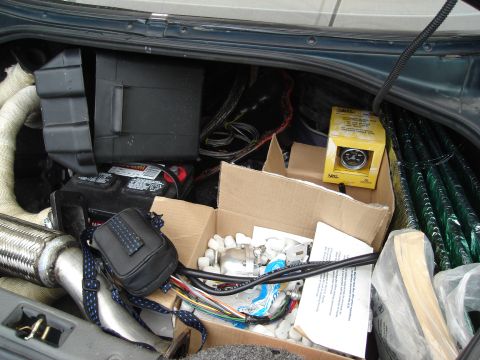 1995 Mazda MX-6 - Car trunk contains various parts and a battery, obscuring any view of the vehicle itself.