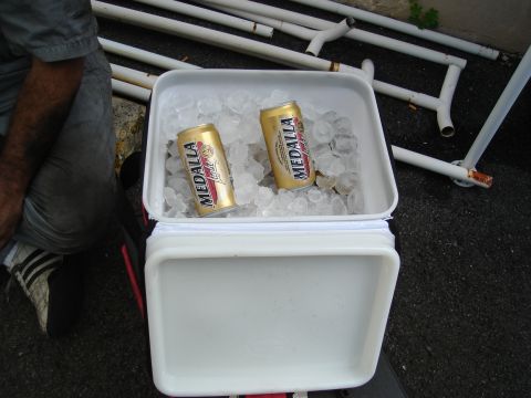 1995 Mazda MX-6 - A cooler is filled with ice and two cans of Medalla Light beer, with a person partially visible to the side.