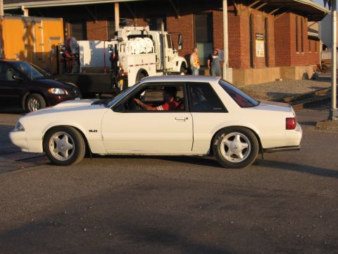 1989 Ford Mustang - A white 1987 Ford Mustang coupe is captured in a side profile, with a 5.0 badge visible on the fender.