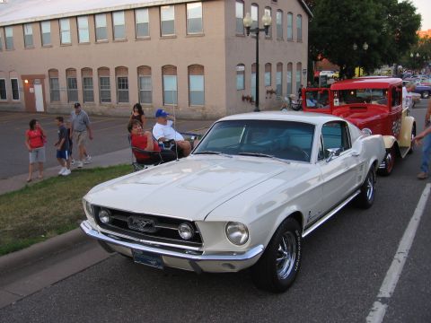 1989 Ford Mustang - A classic Mustang is displayed at a car show with other vehicles present.