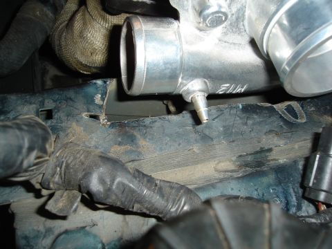 1995 Mazda MX-6 - Aluminum intercooler pipe with vacuum nipple and etched markings, part of an engine bay.