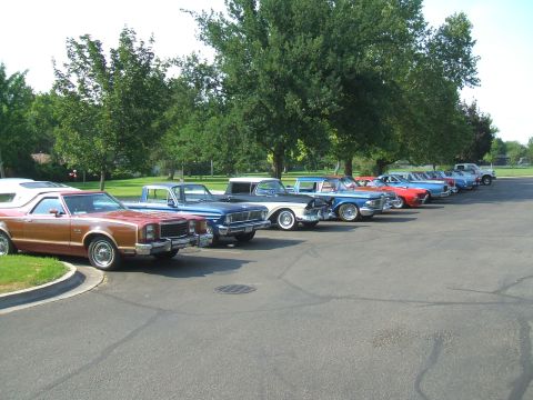 1974 Ford Ranchero - A row of vintage vehicles, including a 1977 Ford Ranchero, are parked outside on a sunny day.