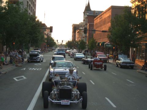 1974 Ford Ranchero - A parade of classic cars and hot rods fills a city street with onlookers on the sidewalks.