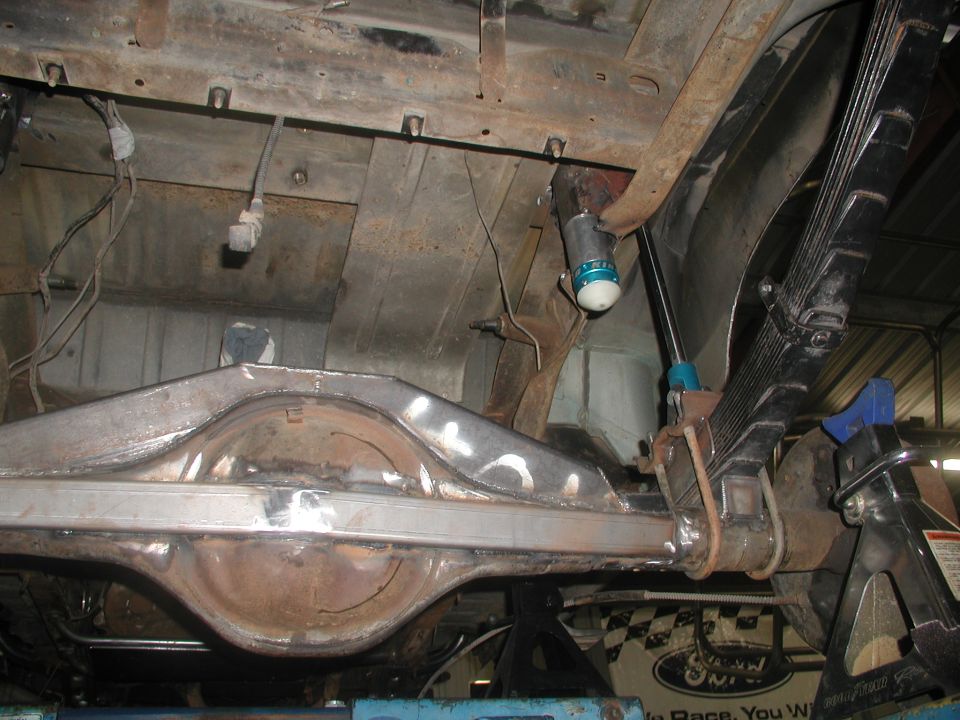 Underside view of a truck rear axle, leaf springs, and shock