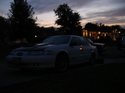 1993 Ford Taurus - A white 1993 Ford Taurus sedan is parked outside during twilight.