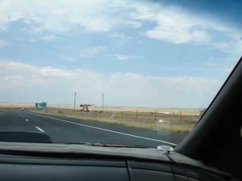 1993 Ford Taurus - A roadside dinosaur statue is visible from the highway on a partly cloudy day.