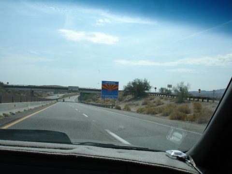 1993 Ford Taurus - Driving into Arizona, passing a welcome sign and an overpass on a sunny day.