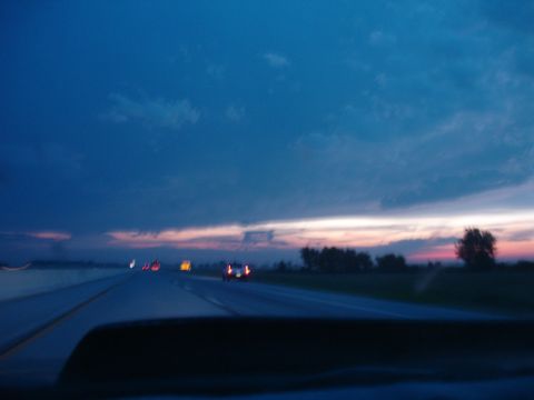 1993 Ford Taurus - Driving on the highway as the sun sets, with other cars visible ahead.
