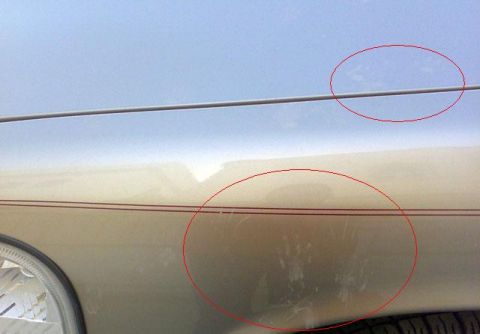 2007 Mercury Grand Marquis - Scratches and scuffs are visible on the side of a car's fender.