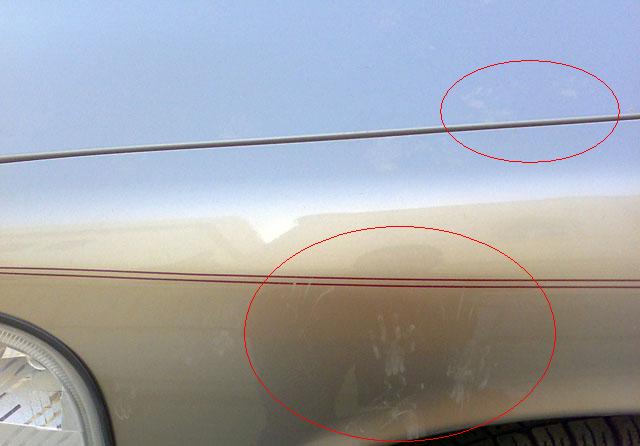 side of car fender with red pinstripe and scratches circled