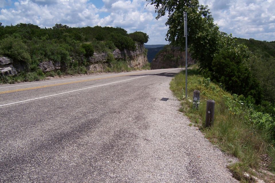 Winding road through a wooded, rocky landscape