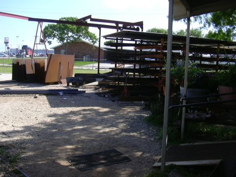 1995 Ford Bronco - A scene depicting industrial shelving and stacked metal sheets in an outdoor storage area.