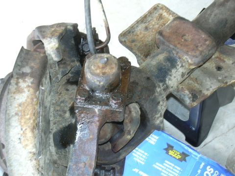 1995 Ford Bronco - Close-up view of a rusty differential housing and suspension components, with a Supermotors.net logo in the lower right corner.