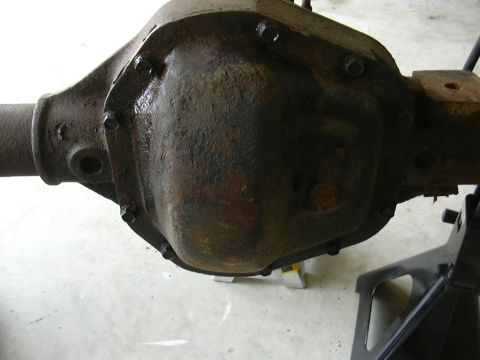 1995 Ford Bronco - Close-up of a heavily rusted rear axle differential housing, likely removed for repair or modification.