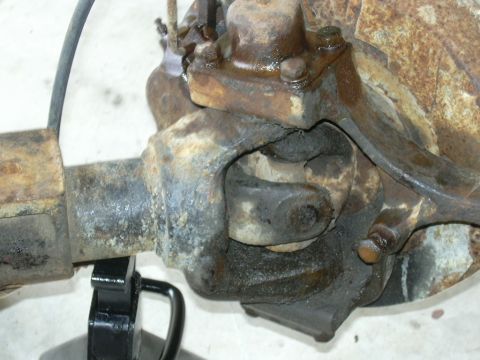 1995 Ford Bronco - This photo shows a close-up of a rusty front axle differential housing and U-joint.