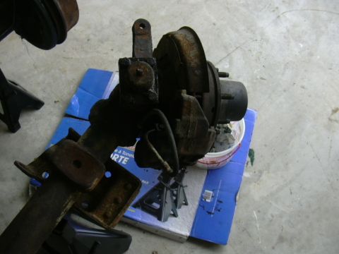 1995 Ford Bronco - A front axle assembly with brake components is shown, resting on a blue box.
