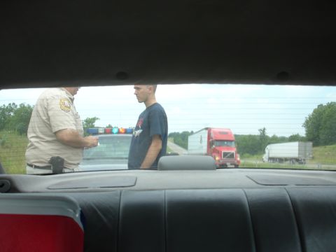 1993 Ford Taurus - Traffic stop on the highway with two large trucks visible in the background.