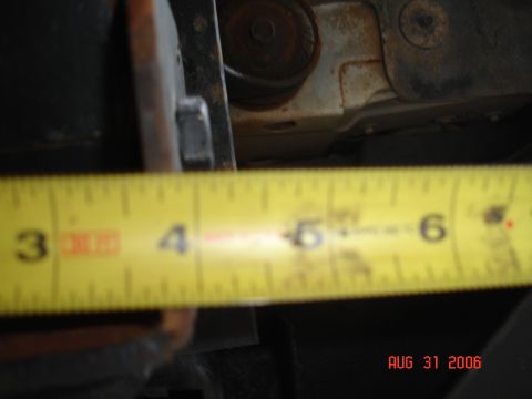 1995 Ford Bronco - Measuring the clearance under the vehicle's frame with a tape measure.