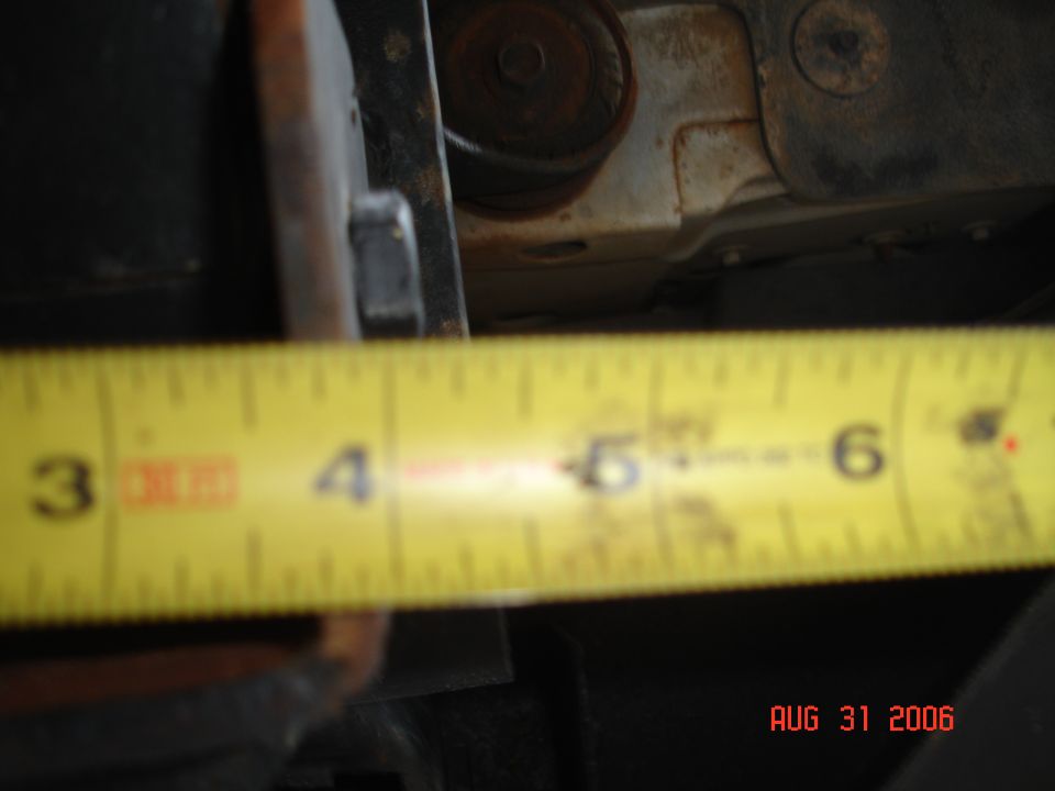 Tape measure showing about 5 inches of clearance under a vehicle frame