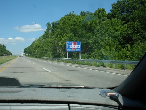 1993 Ford Taurus - View from a car dashboard shows a highway scene with a sign welcoming travelers to Indiana.