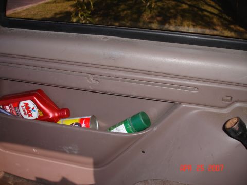 1995 Ford Bronco - The interior door panel shows a storage compartment holding various automotive fluids and sprays.