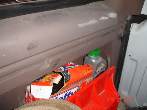 1995 Ford Bronco - A close-up view of a vehicle's interior storage compartment containing various items.