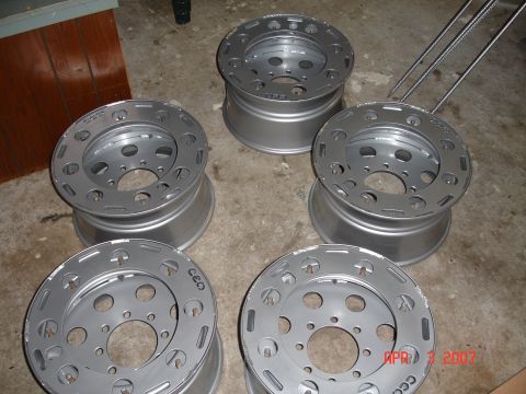 1995 Ford Bronco - Set of five aluminum wheels, possibly for a truck or SUV, shown on a concrete floor.