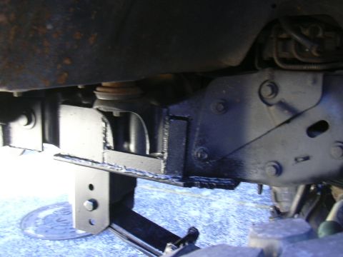 1995 Ford Bronco - Undercarriage view showing frame modifications and suspension components, with a jack supporting the vehicle.