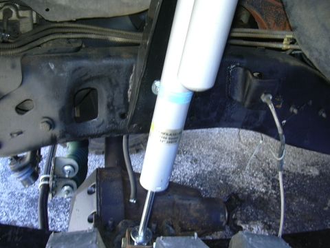 1995 Ford Bronco - Underbody view of a vehicle's suspension system, highlighting a shock absorber and frame components.