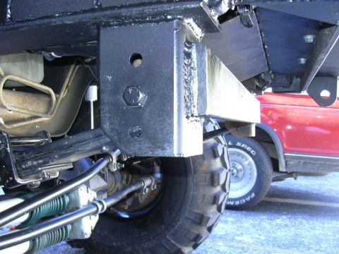 1995 Ford Bronco - Detail shot of custom suspension and frame components on a modified off-road vehicle, with another vehicle in the background.
