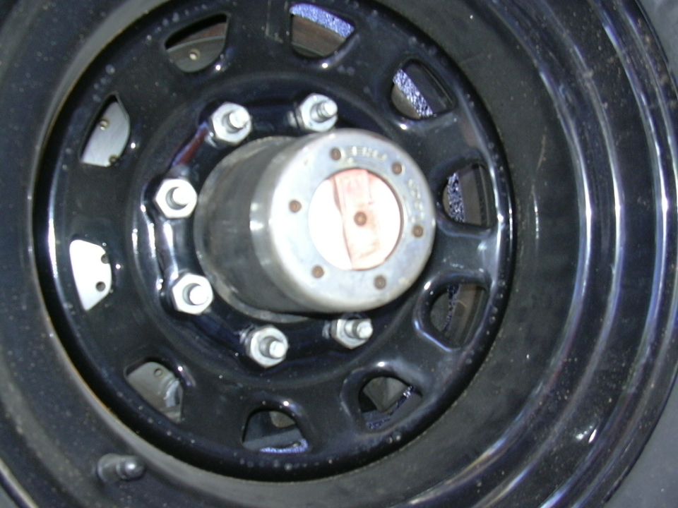 Close-up of a black wheel with a silver hub and lug nuts