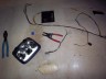 1998 Ford Crown Victoria - A car headlight assembly and its wiring harness are laid out on the floor with tools.