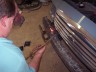 1998 Ford Crown Victoria - A person is shown working on the front grille of a vehicle in what appears to be a garage.