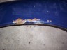 1998 Ford Crown Victoria - Close-up of a blue car part showing damage and corrosion.