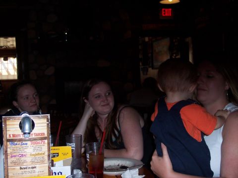 1972 Ford Ranchero - A group of people are gathered around a table in a dimly lit restaurant, with menus and drinks visible.