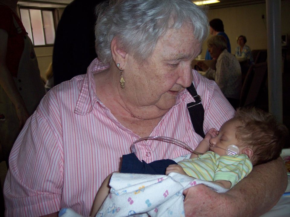 Woman holding a baby with medical tubing