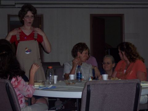 1972 Ford Ranchero - A group of people are gathered around a table, with one woman standing and gesturing.